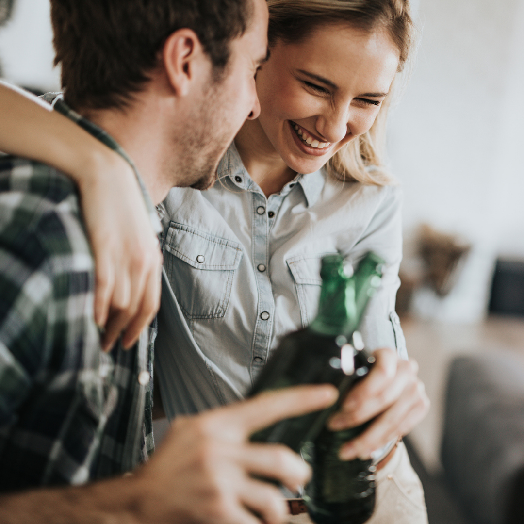 Couple laughing while having a drink